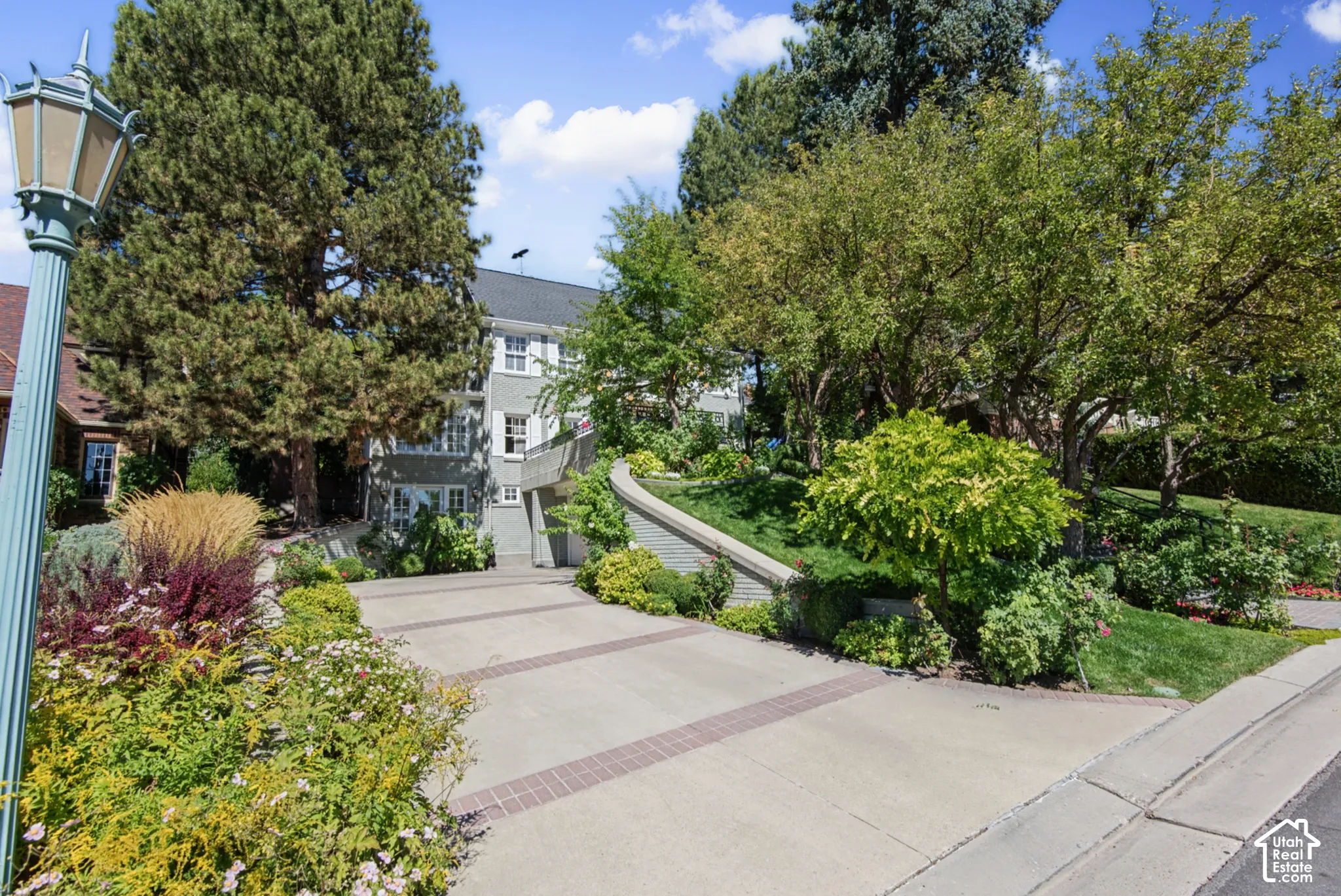 Concrete driveway with brick accents and a decorative street lamp