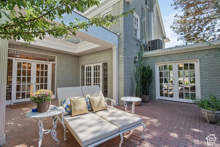 Brick patio featuring a herringbone pattern, multiple sets of glass-paned French doors, and a skylight-covered outdoor area