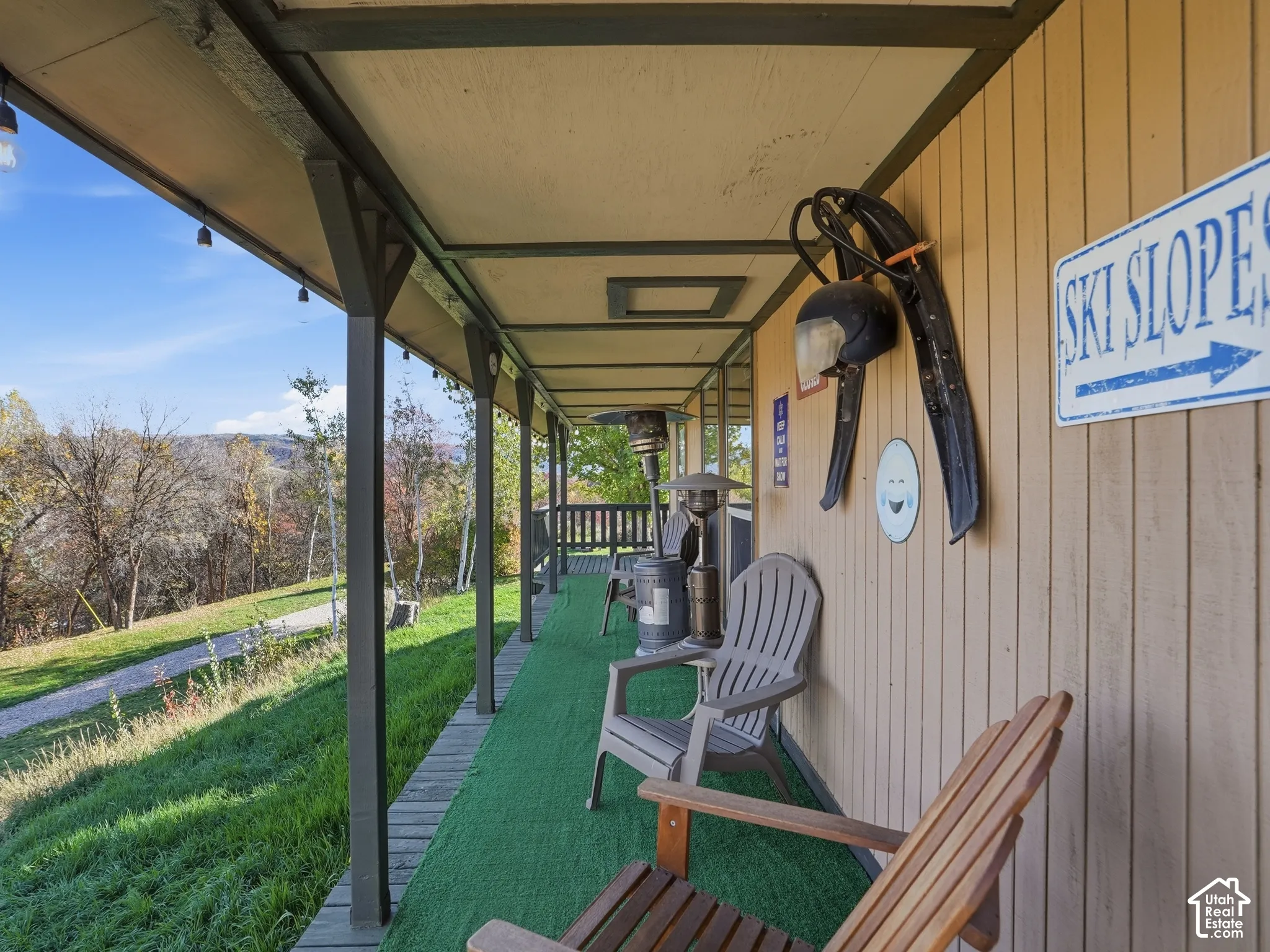 Covered exterior porch featuring vertical wood siding, structural support posts, and an expansive mountain terrain backdrop