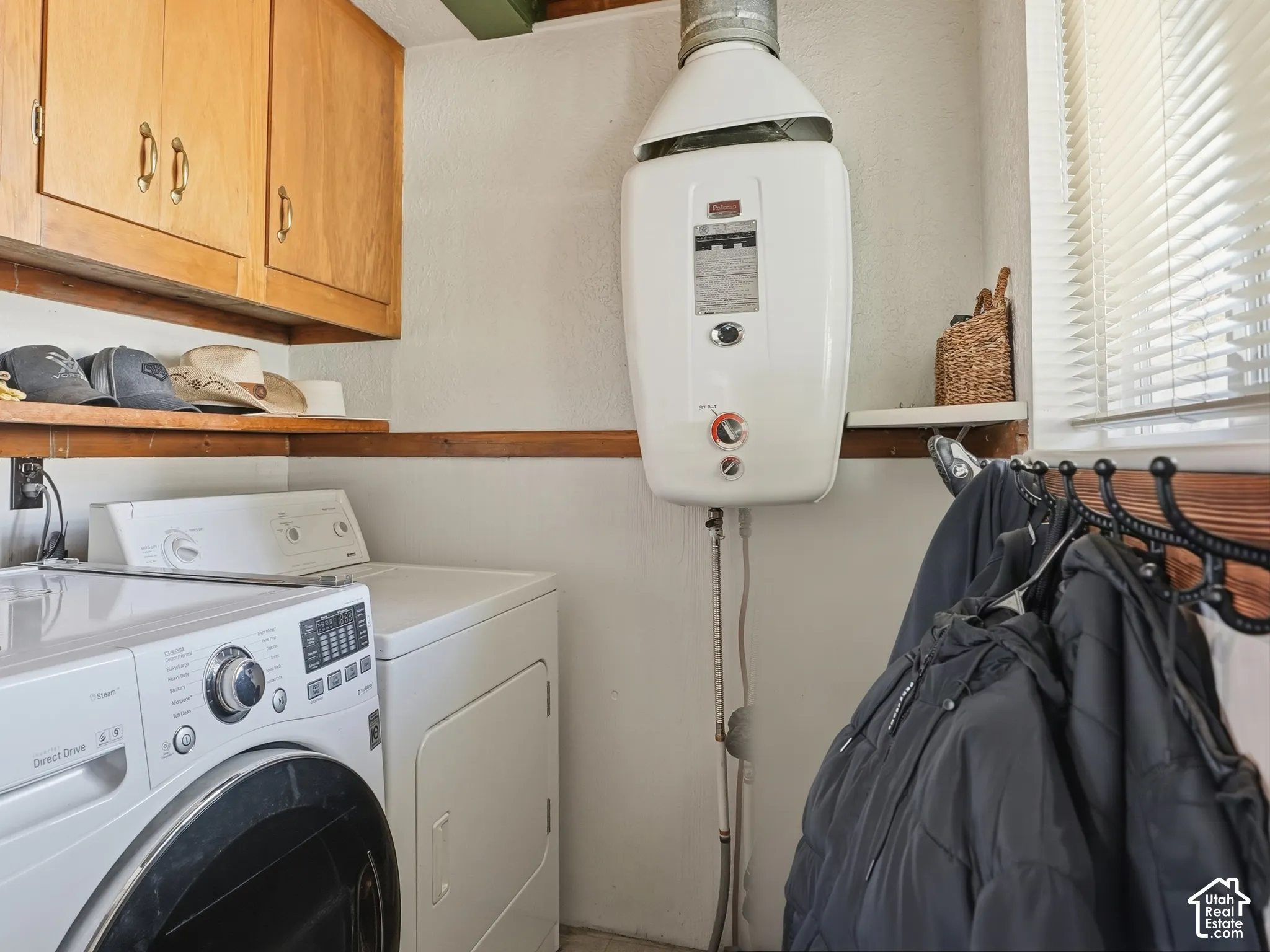 Wall-mounted tankless water heater, natural wood cabinetry, exposed wood ceiling beams, and horizontal wood shelving