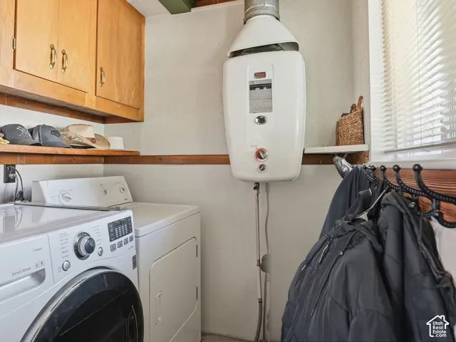 Wall-mounted tankless water heater, natural wood cabinetry, exposed wood ceiling beams, and horizontal wood shelving