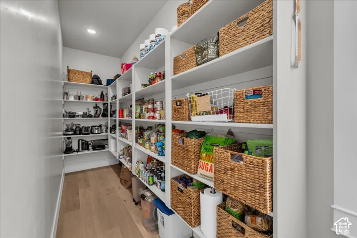 Built-in shelving with extensive storage, recessed lighting, and wood-finish flooring