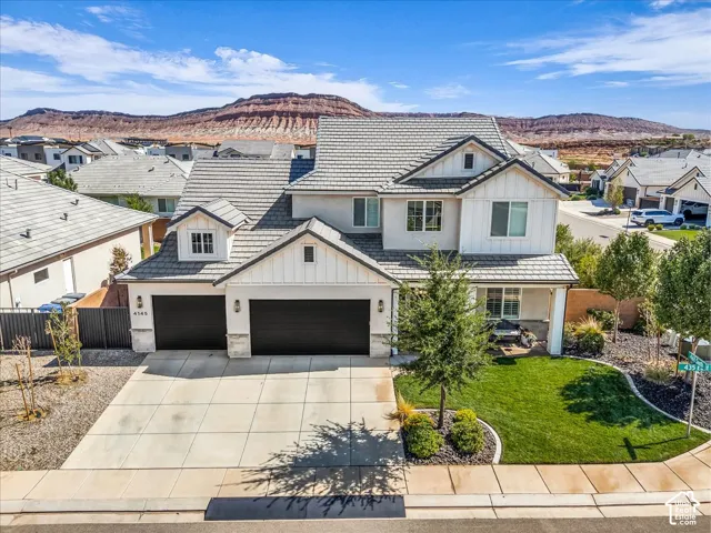 Two-story residence with a gray shingle roof, white siding, and stone accents