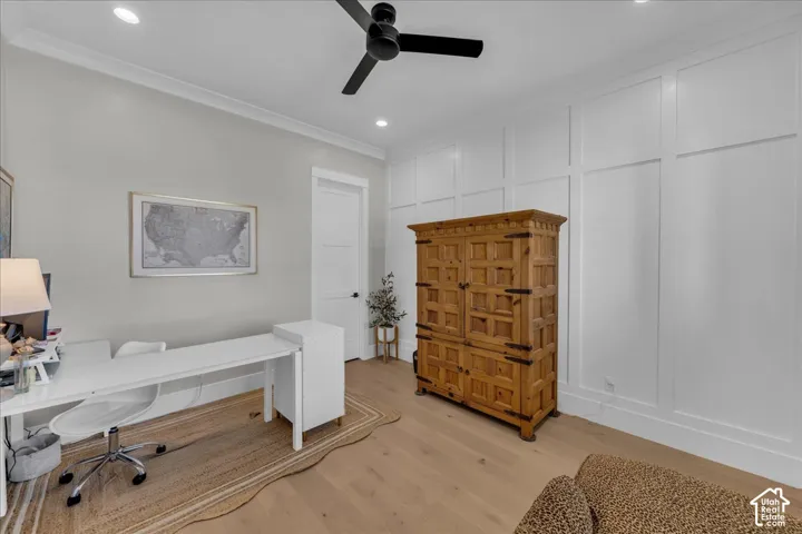 White board and batten wall paneling, crown molding, recessed lighting, wood-finish flooring, and a black ceiling fan