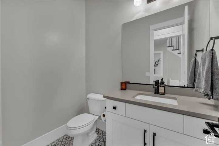 White vanity with a built-in rectangular sink, light-toned countertop, and matte black faucet