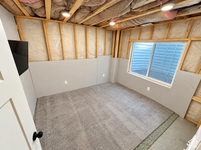Unfinished space with installed drywall, recessed lighting, and a large egress window