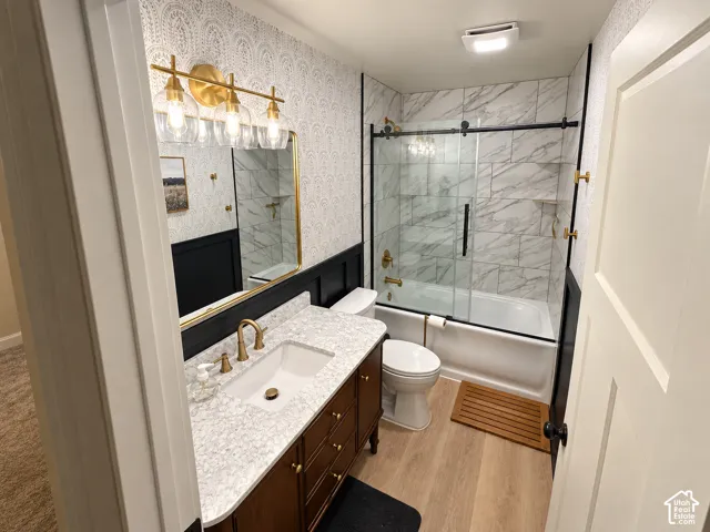 Bathroom featuring a single vanity with a white rectangular sink, a dark wood-finish cabinet, a light-toned countertop, and gold-toned fixtures