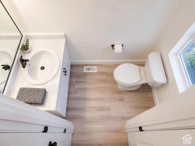 White vanity with a round undermount sink, matte black faucet, and white countertop