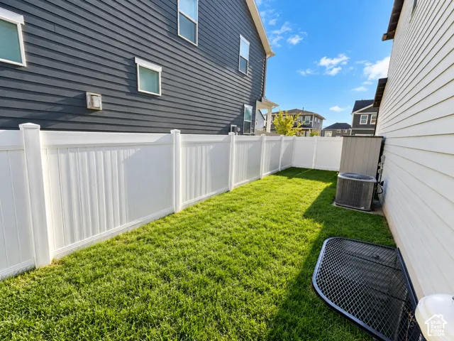 Expansive grassy area featuring white privacy fencing