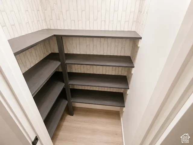 Built-in shelving with wood-finish construction, light wood-finish flooring, and light-toned wall covering