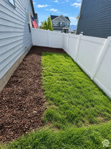 Manicured lawn area with a white vinyl fence
