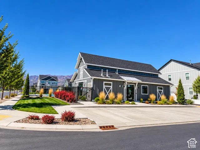 Modern barn-style architecture with dark gray siding, a black shingle roof, and white trim