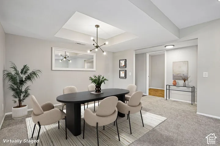 Recessed ceiling with a modern chandelier, light gray carpeting, and light gray wall paint