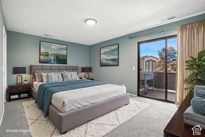 Sliding glass doors opening to a private balcony, flush mount ceiling lighting, and wall-to-wall carpeting