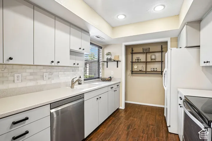 Light-toned cabinetry with black hardware, stainless steel dishwasher, white subway tile backsplash, and recessed lighting