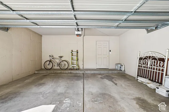 Attached garage featuring a concrete floor and a paneled entry door