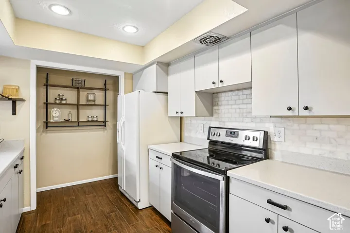 Recessed lighting, wood-finish flooring, white cabinetry, solid surface countertops, and subway tile backsplash