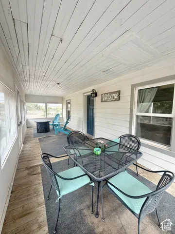Covered porch with wood-finish flooring and vaulted shiplap ceiling