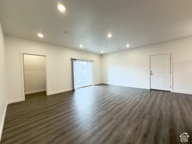 HUGE family room featuring LVP flooring throughout, recessed ceiling lighting, and glass sliding door to the balcony. Storage closet as well.