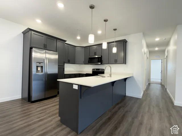Kitchen featuring LVP flooring, recessed lighting, a quartz island & pendant lighting