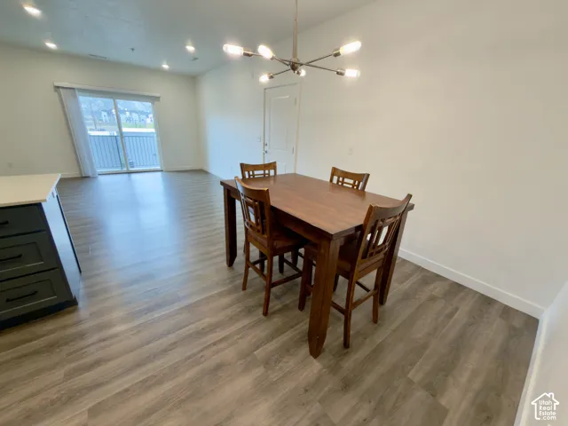 LVP flooring throughout, featuring a modern light fixture, recessed lighting, and sliding glass doors to balcony