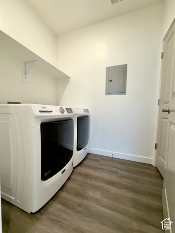 Laundry area featuring LVP flooring, a white storage shelf, and a light-colored door Utility closet accessed from this room