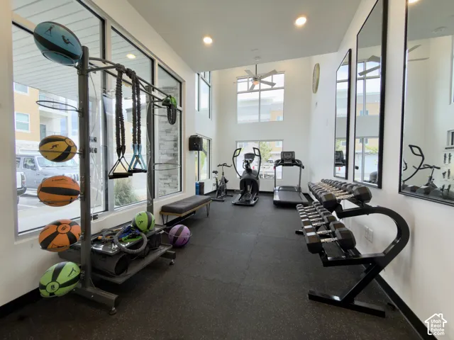 Clubhouse fitness center featuring large windows, recessed lighting, and a ceiling fan