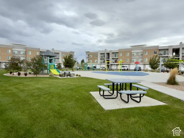 Expansive green space featuring a picnic area, playground equipment, and a splash pad