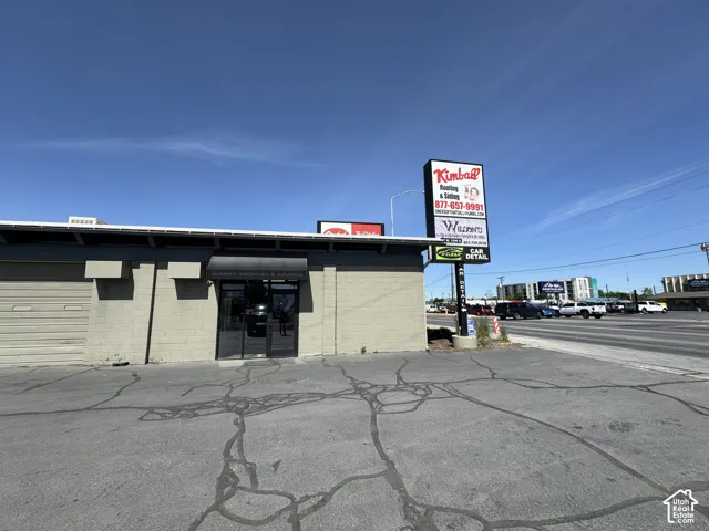 Commercial building featuring a roll-up door, glass entry doors, and a prominent pole sign