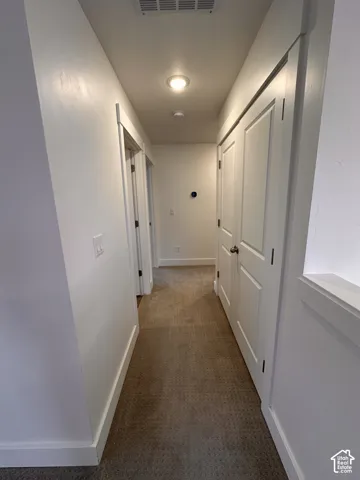 Recessed lighting, white paneled doors, neutral carpeting, and white trim