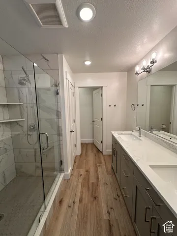 Glass-enclosed shower with tiled walls. Deep towel closet. Dual Vanity and a private toilet.