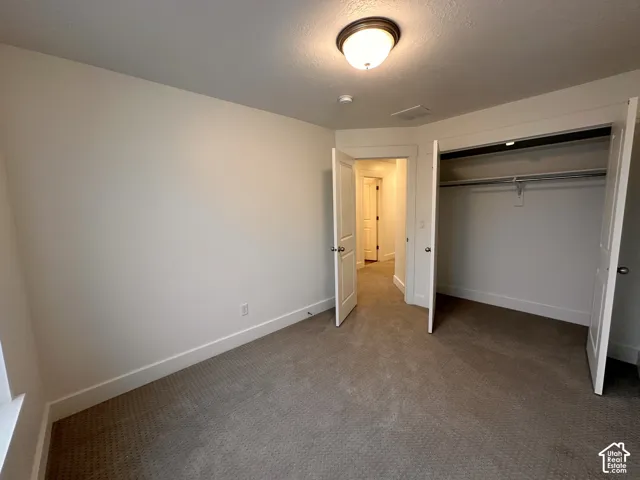 Carpeted room with a flush mount ceiling light fixture
