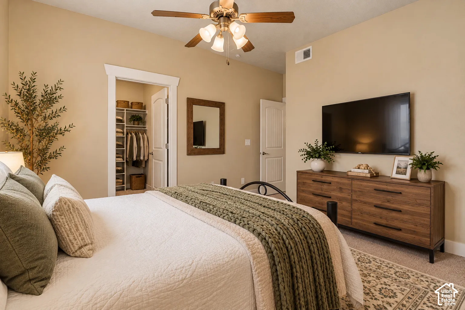 Ceiling fan with integrated lighting, recessed closet with built-in shelving, paneled interior doors, and neutral wall paint