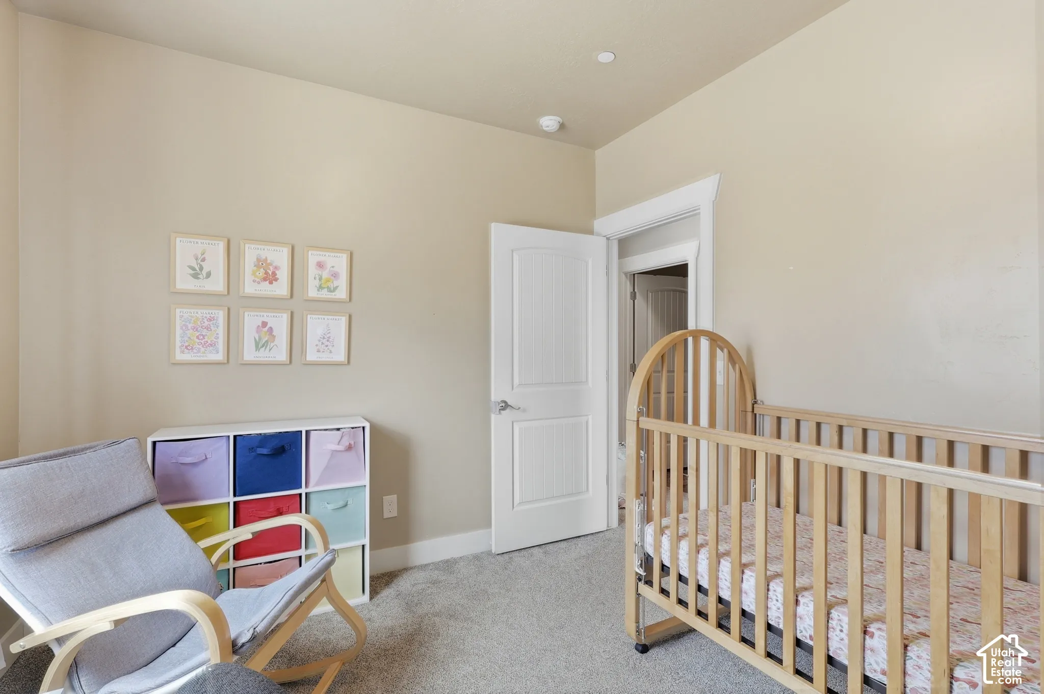 Carpeted room featuring neutral wall paint, white trim, and a white interior door