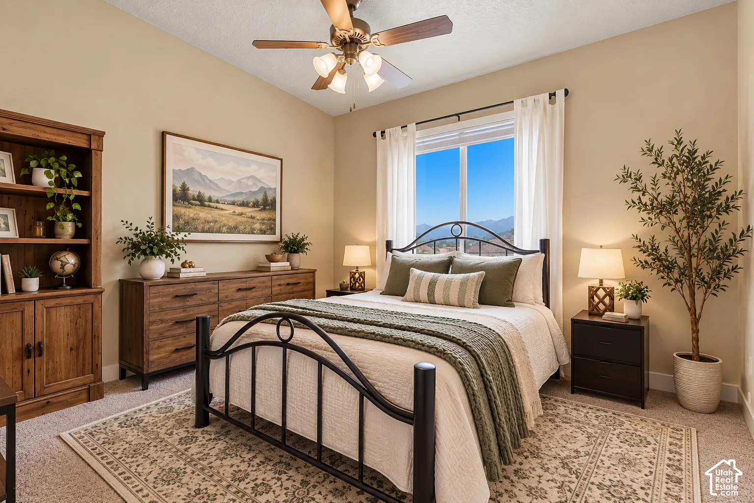 Vaulted ceiling with a ceiling fan, window with mountain scenery, and carpeted flooring