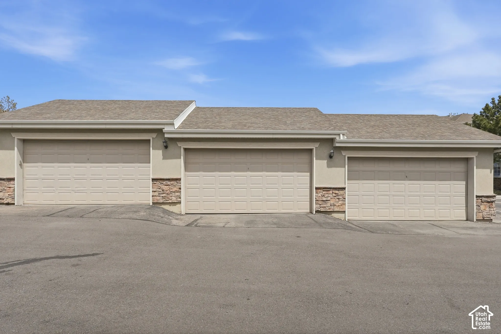 Exterior featuring three individual garage doors, each with paneled construction