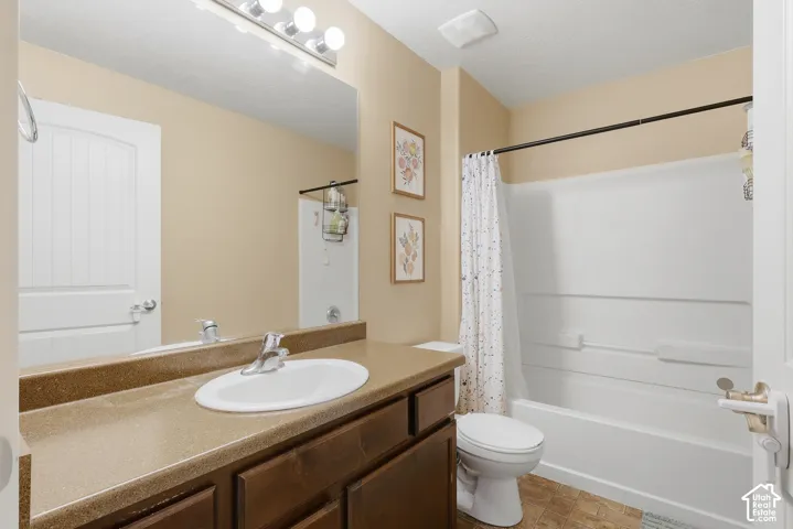 Bathroom featuring a single vanity with a laminate countertop, built-in sink, and chrome faucet