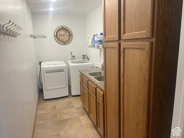 Laundry area featuring wood-finish cabinetry, a built-in utility sink, and recessed lighting