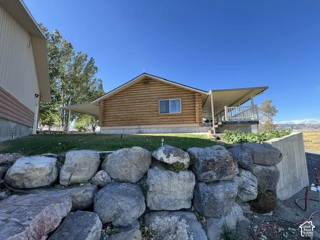 Log cabin exterior featuring a covered porch, wood siding, and gabled roofline