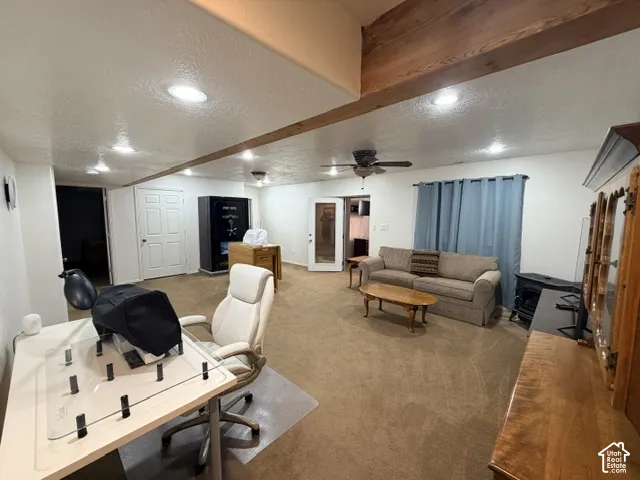 Recessed ceiling lighting, exposed wood ceiling beams, ceiling fan, and French doors