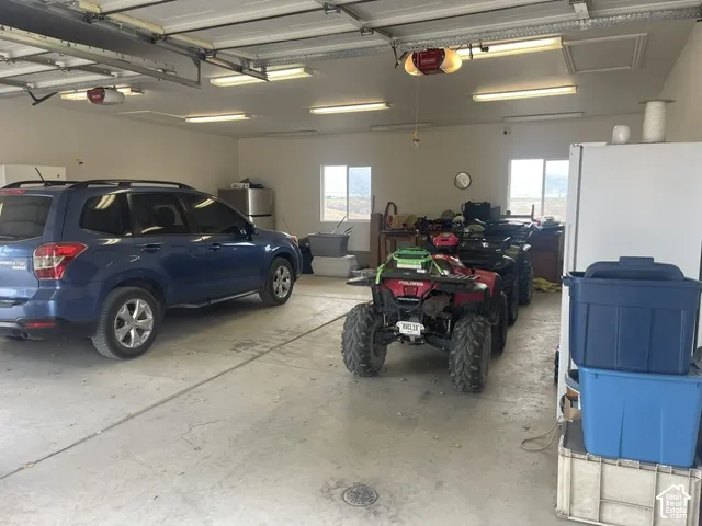 Spacious garage with multiple overhead doors, concrete flooring, and ample lighting