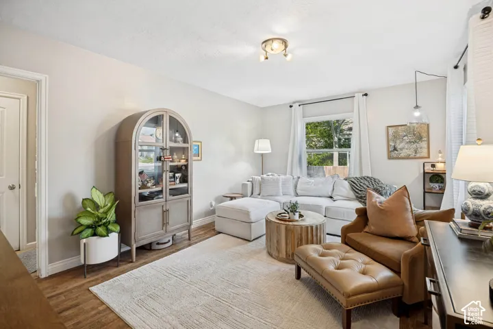 Recessed window with natural light, wood-finish flooring, ceiling-mounted lighting, and neutral wall tones