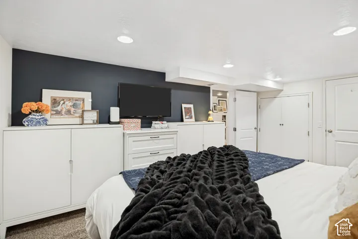 Recessed lighting, dark accent wall, white built-in cabinetry, white paneled doors, and carpet flooring