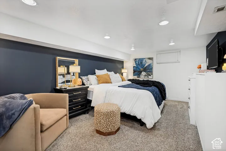 Recessed lighting illuminates the room, featuring a dark accent wall