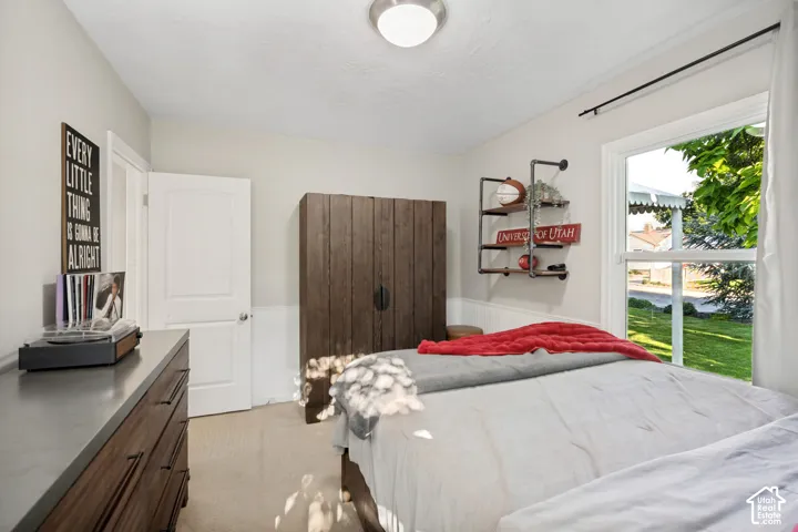 Neutral tone wall paint, white trim, recessed ceiling light fixture, window with outdoor view, and a built-in wall shelf