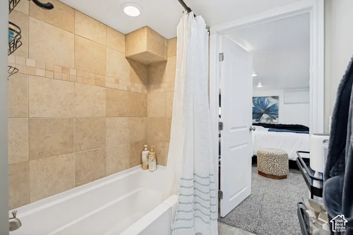 Recessed lighting illuminates the tiled shower surround with an integrated bathtub