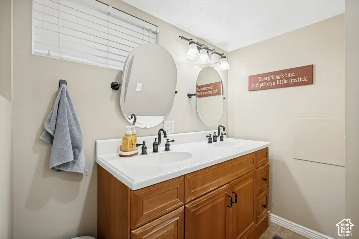 Wood-finish vanity with dual integrated sinks and white countertops
