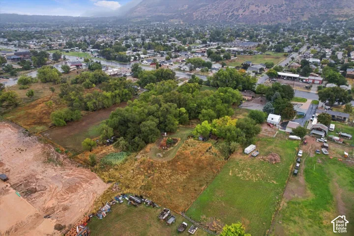 Expansive lot featuring mature trees, varying terrain, and surrounding residential properties
