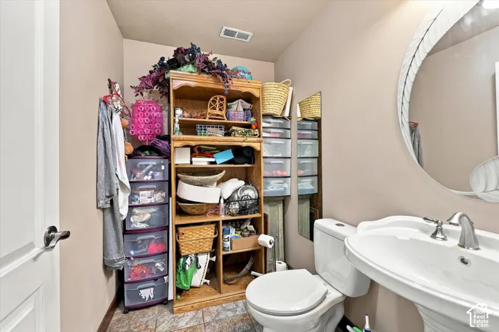 Pedestal sink, two-piece toilet, and tiled flooring