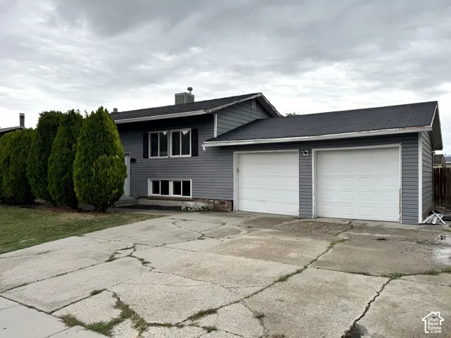 Gray siding exterior with white window frames and a two-car garage